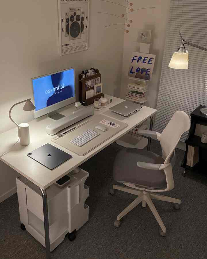 白とグレーのトーンのホームオフィス、シンプルで整頓されたデスクとオフィスチェアが配置された印象的な空間