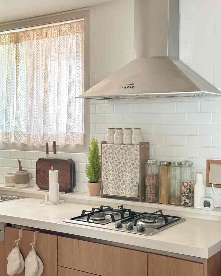 White and wood tone kitchen featuring organized storage items and a clean cooking area with a natural style