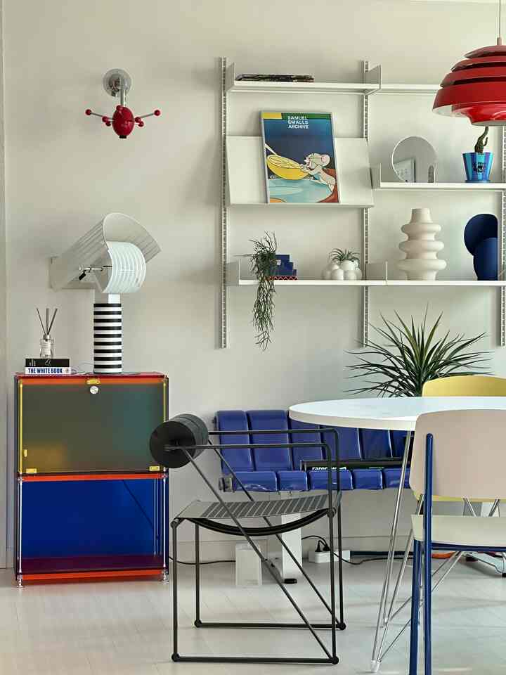 Colorful living room featuring a white round table and diverse chairs arranged in a modern space