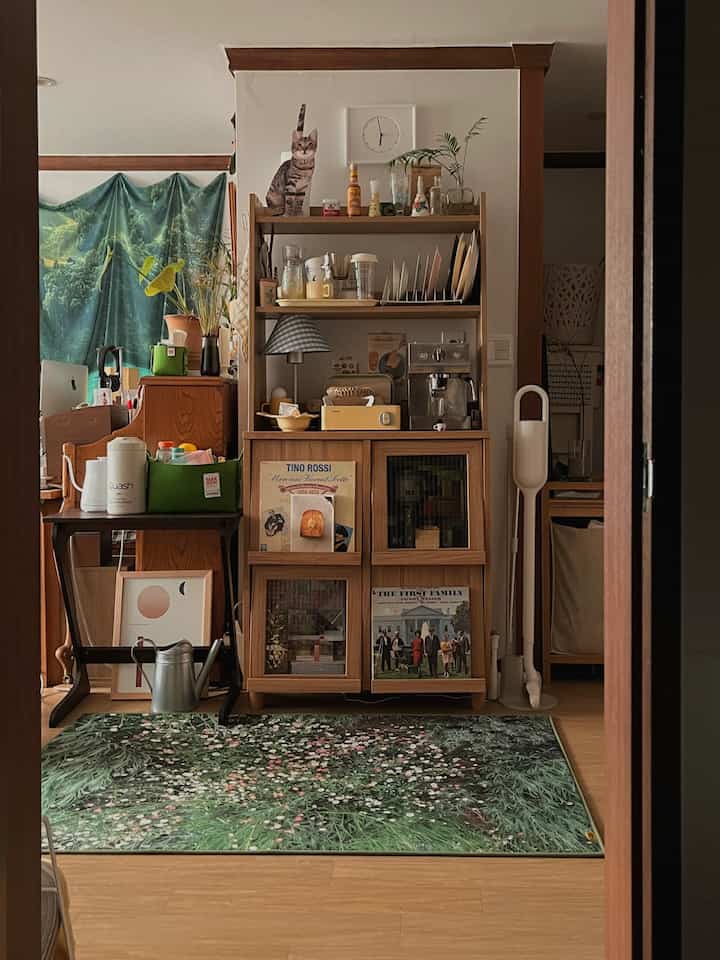 ベージュと木目調が調和したダイニングルーム、花柄のラグと植物が配置された雰囲気のあるインテリア