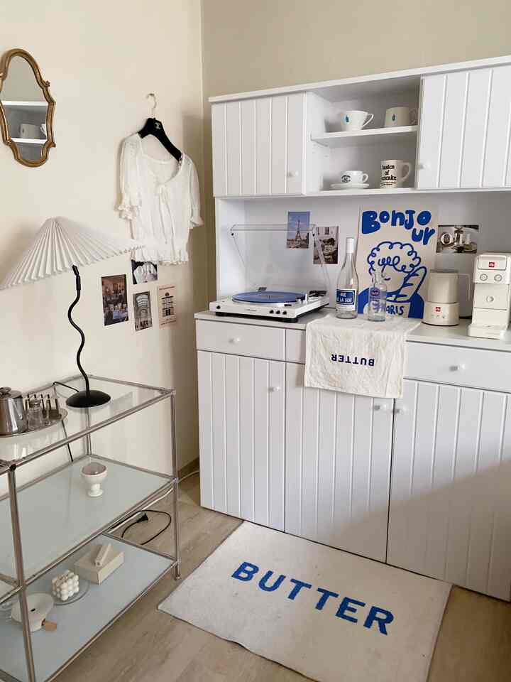 白とベージュの色調のキッチン空間、ホームカフェキャビネットとターンテーブルが配置されたシンプルでモダンな雰囲気のあるインテリア