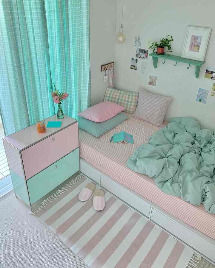 Pastel pink and mint bedroom featuring modular cabinet and curtains, creating a clean and cozy atmosphere