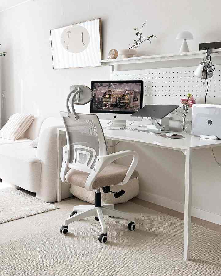 Bright white and natural-toned home office space, featuring an office chair and desk in a modern living-room workspace