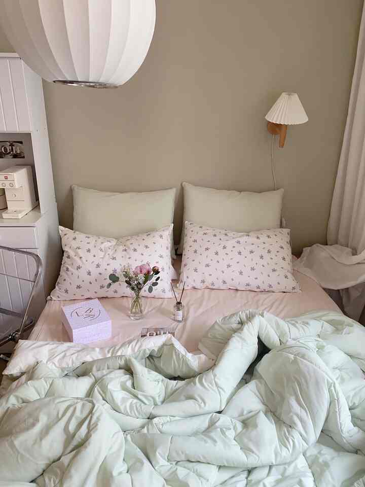 Beige and white toned bedroom featuring soft colored bedding and floral pillows, creating a cozy atmosphere