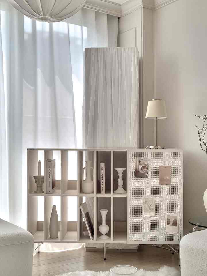 Bright and soft white-toned living room featuring an open archive storage cabinet with natural modern, clean aesthetic