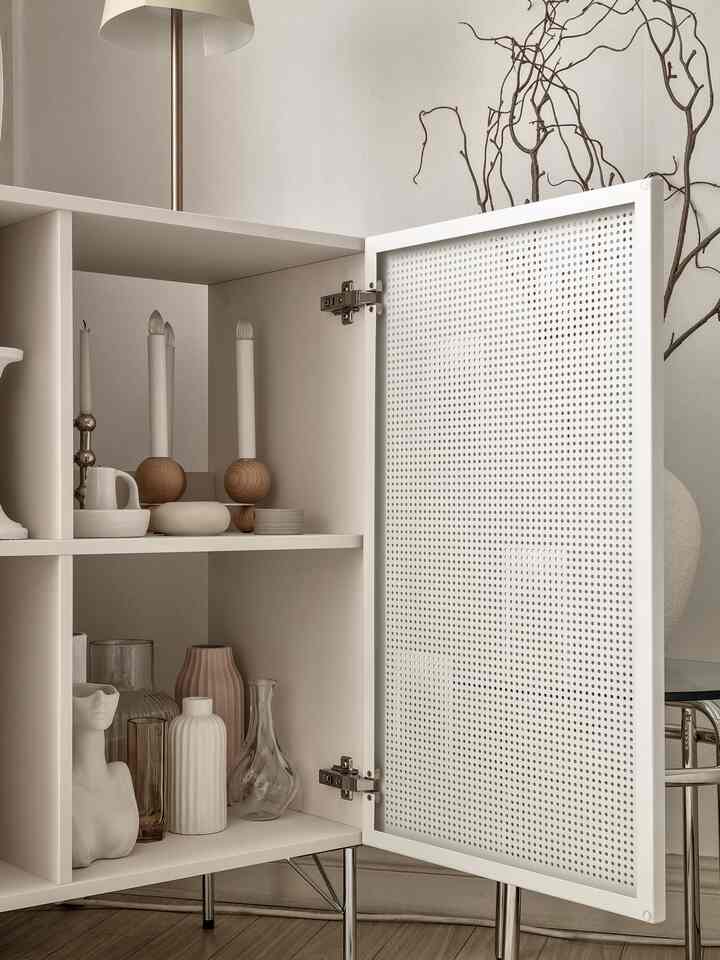 White and natural-toned cabinet space featuring various vases and candles, showcasing a modern and clean interior