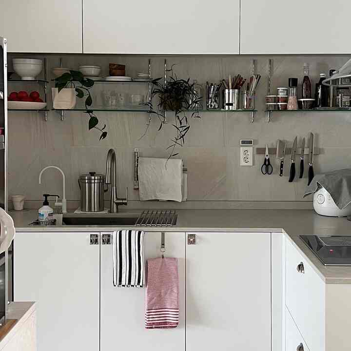 ホワイトとグレーの色調のキッチン、清潔感のあるキャビネットとベスラーグの取っ手が印象的なモダンな空間