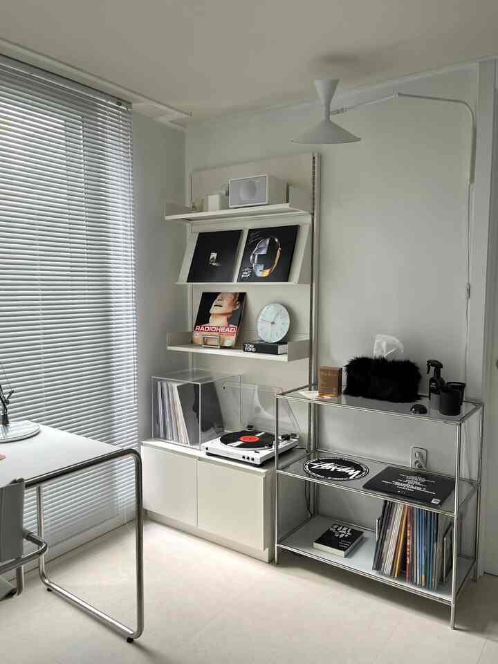 白とシルバーのトーンが調和するモダンなリビングの一角に、ブラインドとオーディオセットが配された印象的な空間