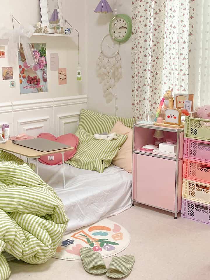 Pastel-toned bedroom featuring striped bedding and a pink storage cabinet, creating a cozy and charming atmosphere.