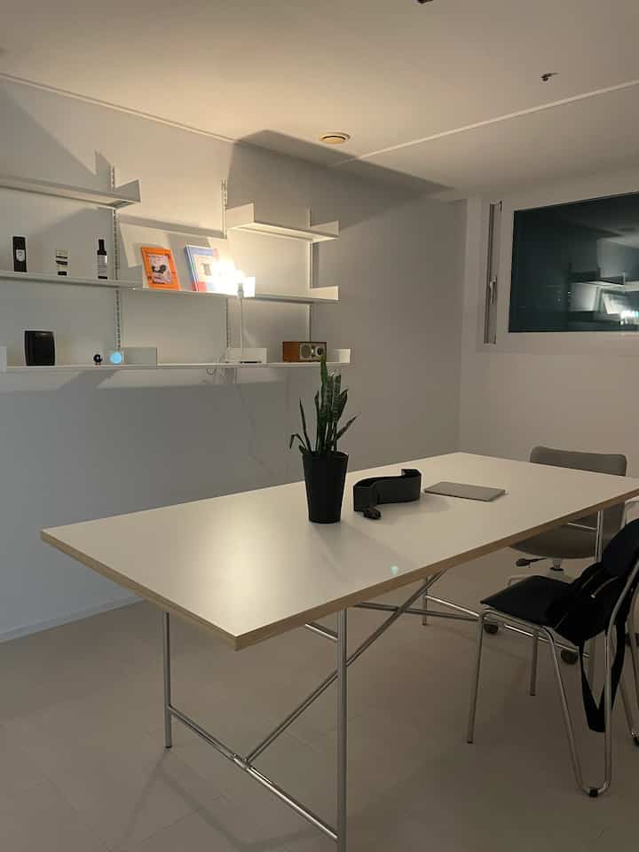 White-toned natural modern dining room featuring a simple dining table with sleek shelving units, creating a calm atmosphere