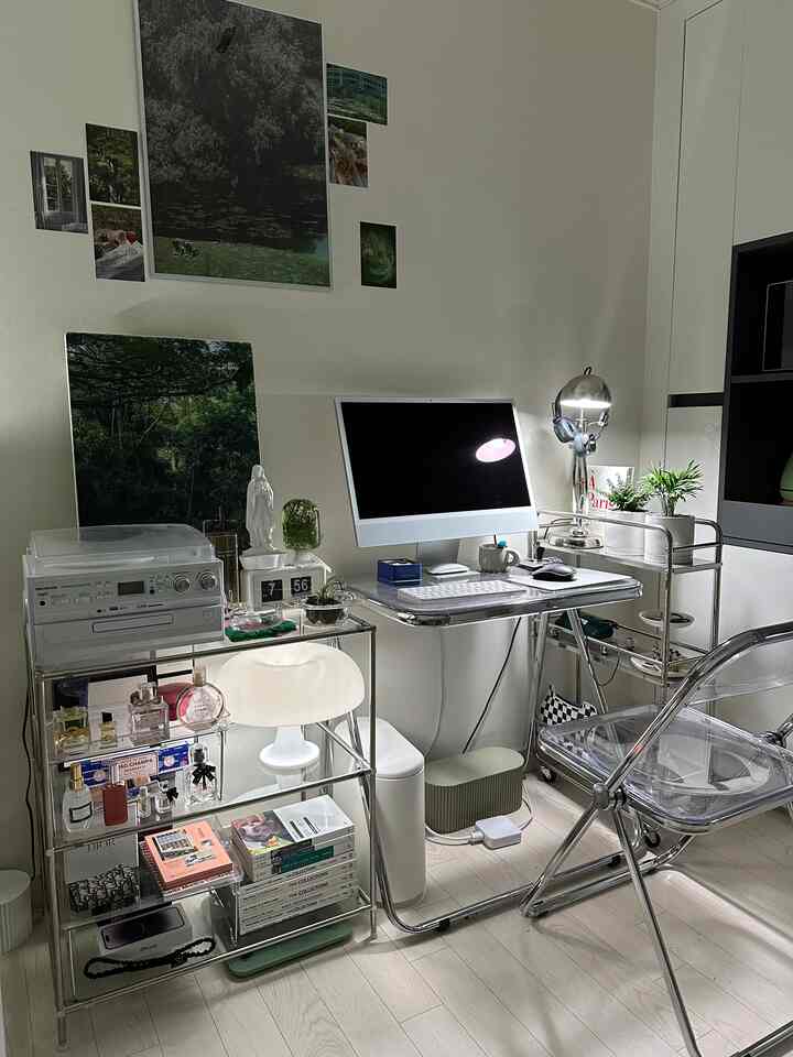 シルバーとホワイトのトーンのホームオフィス、透明な家具と植物が配置された洗練された作業空間