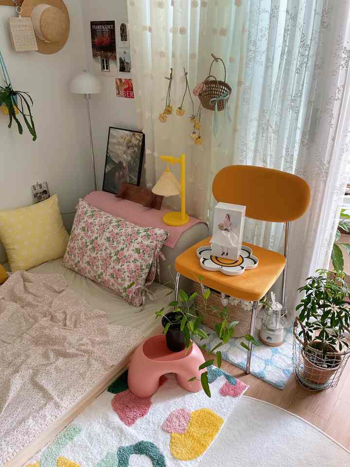 Pastel and yellow-toned bedroom featuring sofa-style bed, potted plants, and yellow chair creating cozy ambiance