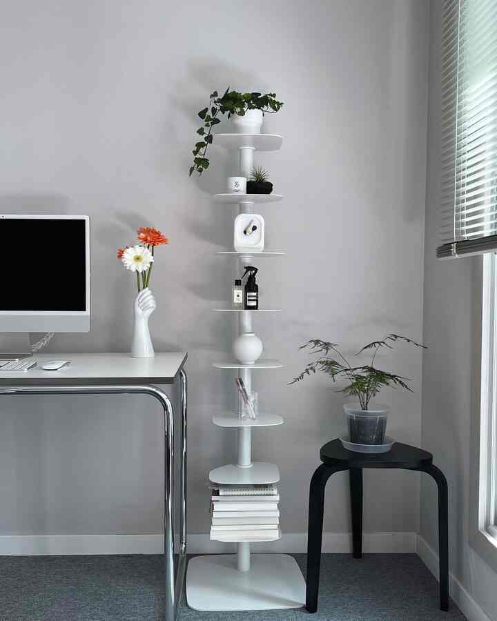 白とグレーの色調の書斎、シンプルなデスクと本棚、植物が配置されたミニマルな雰囲気のワンルームインテリア