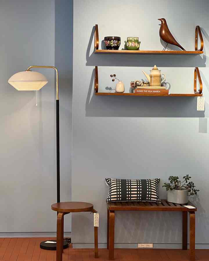 A small Nordic-style living space with soft blue walls and natural wood tone furniture creating a calm atmosphere