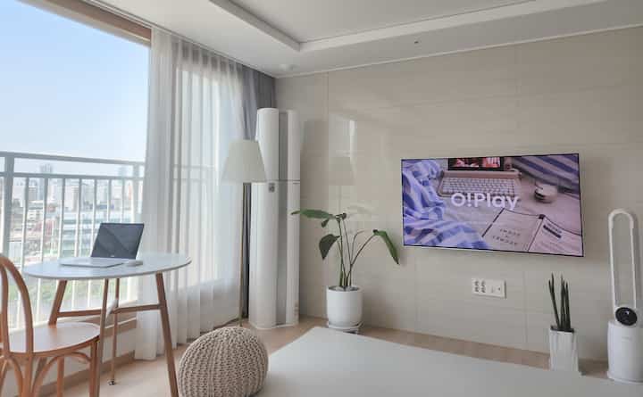 White and wood tone living room featuring a dining table with laptop creating a cozy modern space