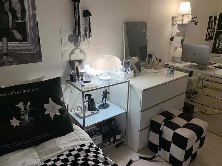 Cozy white and black-toned single bedroom featuring a desk and stool for remote work setup