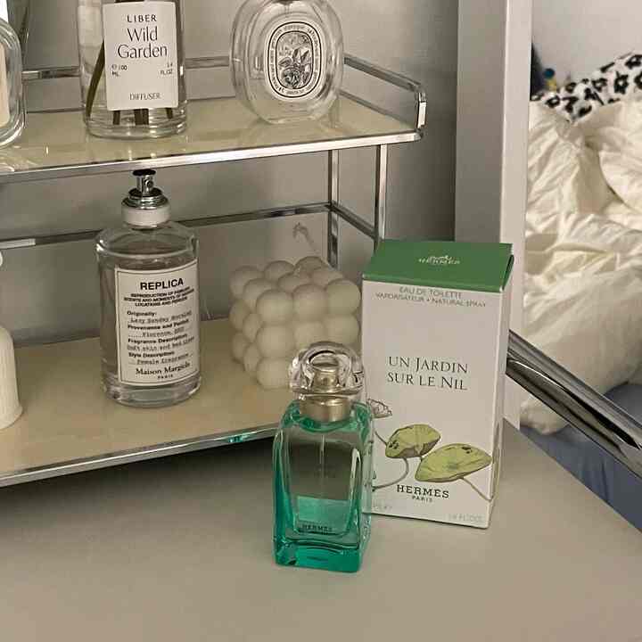 Silver-tone vanity featuring perfumes, diffuser, and a unique bubble candle on a clean surface