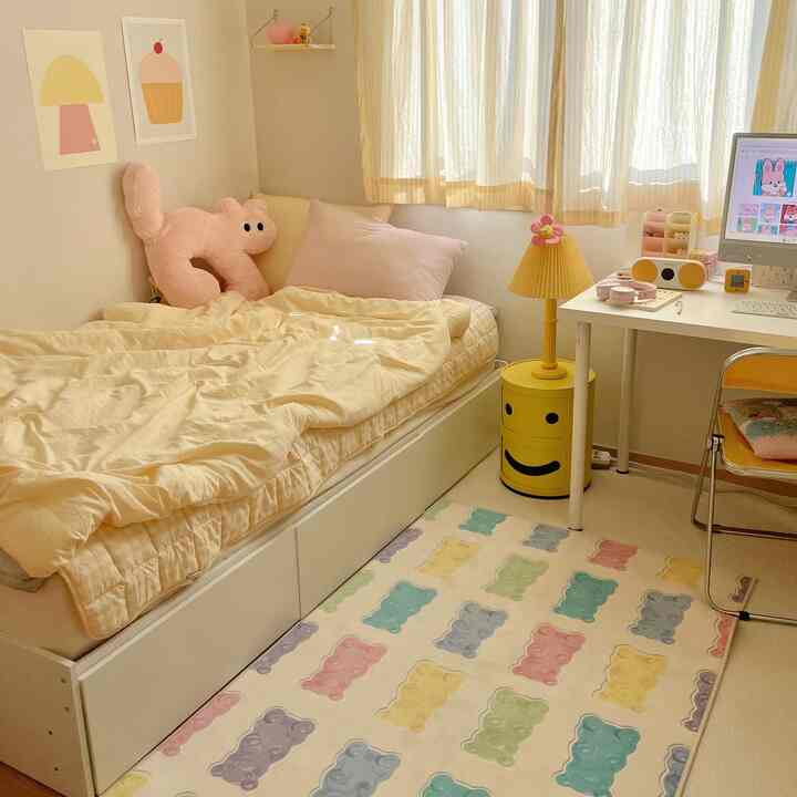 黄色と白のトーンの6畳寝室で、ベッドとデスク、かわいいカラフルなラグが調和した雰囲気のある空間