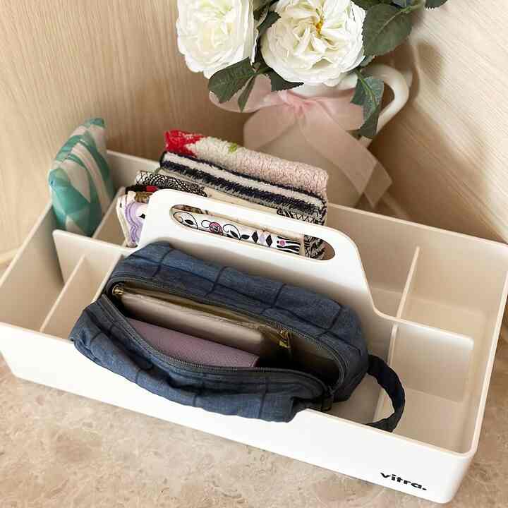 White tray organizing towels and pouch in a neat and minimal space