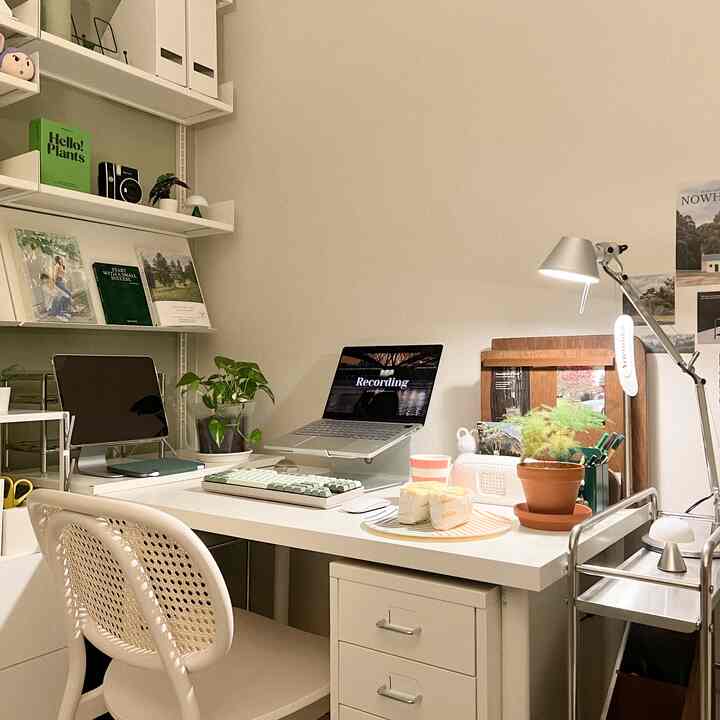 Bright white-toned home office featuring a clean desk and office chair, with organized storage and natural wood accents creating a cozy atmosphere