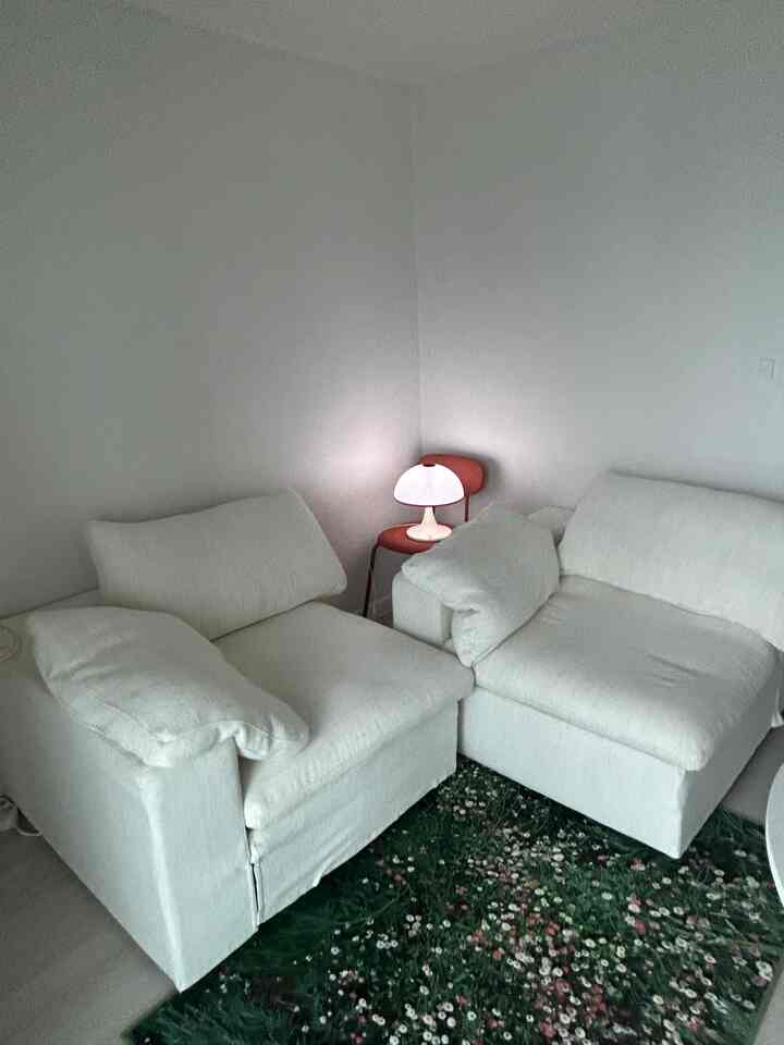 白を基調としたリビング、2つのソファとレトロ調の照明が配置された雰囲気のある空間