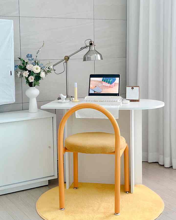 Bright white dining room space featuring yellow accent chair and rug, set up with a neat home cafe atmosphere