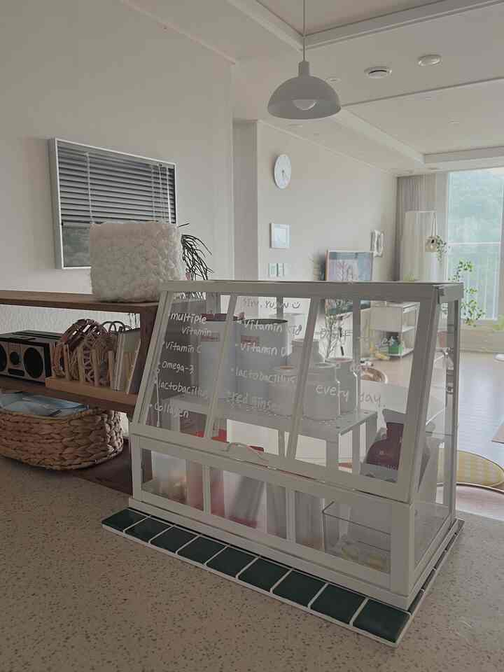 Natural and wood-toned studio apartment kitchen featuring a transparent storage box and dining table in a clean interior