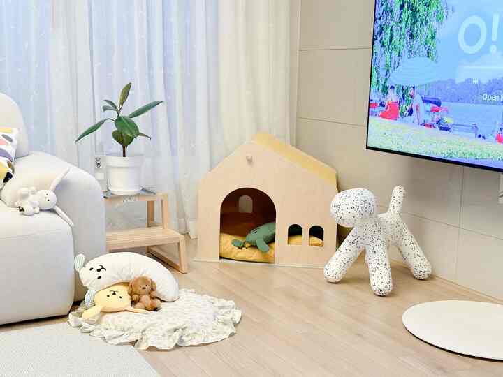 White and wood-toned living room featuring a pet house and dog toys in a natural and simple atmosphere