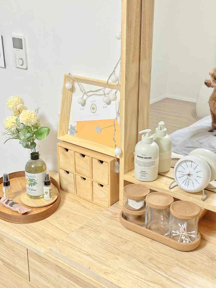 ベージュとナチュラルカラーの寝室、木製化粧台と小物が配置された雰囲気のあるインテリア