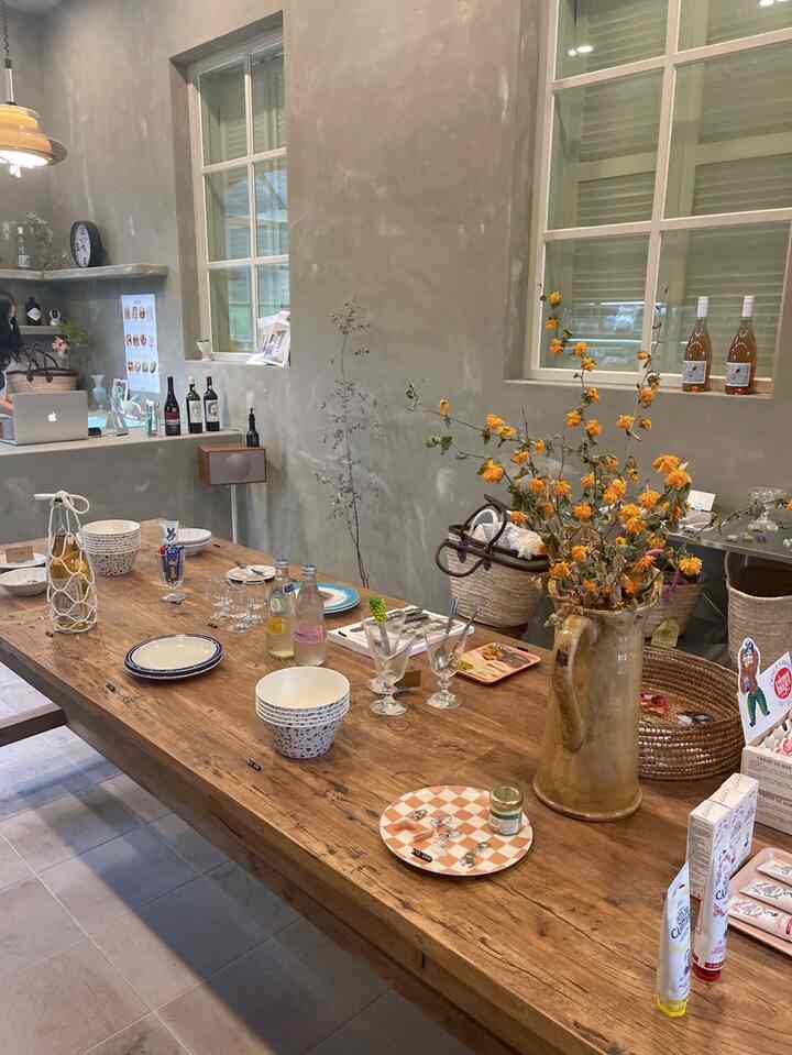 ナチュラルなブラウン色調のキッチン空間、大型の古材テーブルに皿とドライフラワーが配置されたヴィンテージな雰囲気のインテリア