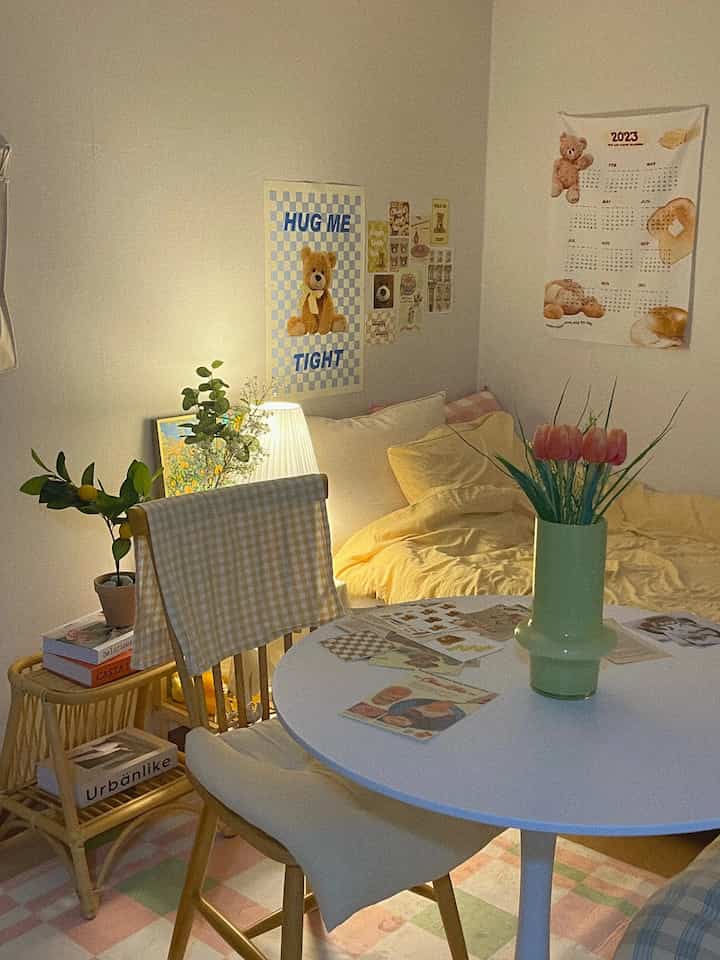 暖かい黄色とナチュラルな木目調が調和したワンルームの寝室とダイニングスペース