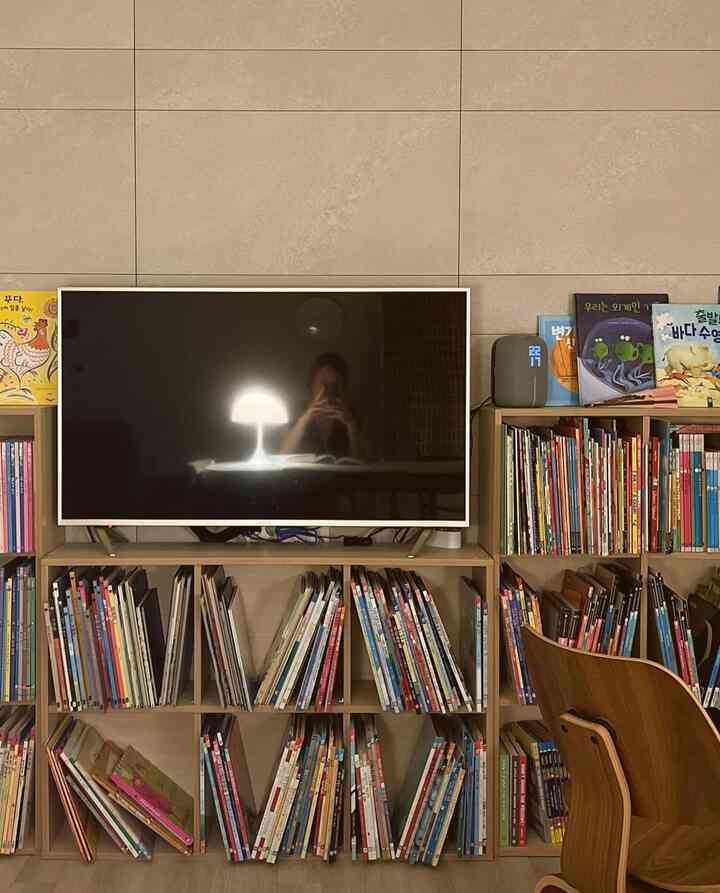 Wood tone living room featuring multiple bookshelves and a table lamp with a cozy atmosphere for parenting