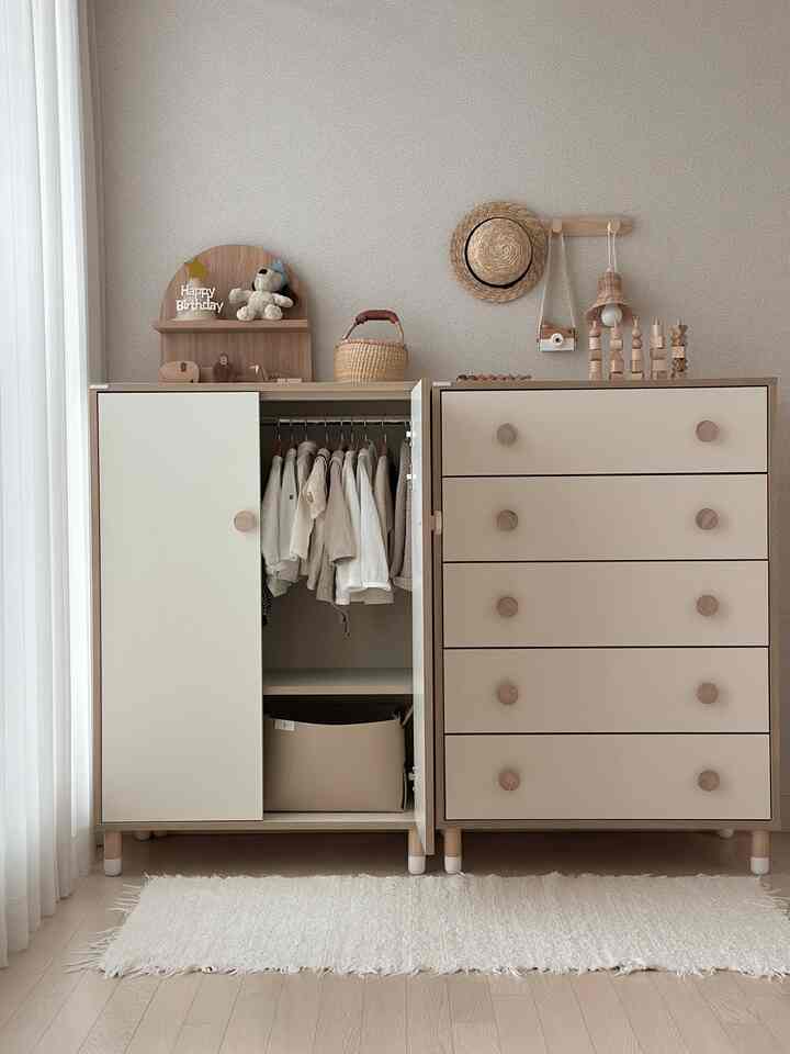 Beige and white toned kids' room featuring a natural, tidy storage space with a baby dresser and closet