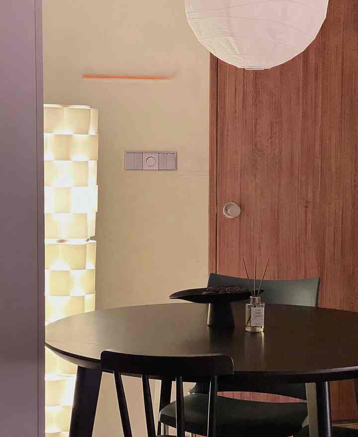 暖かいナチュラルトーンのダイニング、丸いダイニングテーブルとペンダントライトが配置されたシンプルモダンなインテリア