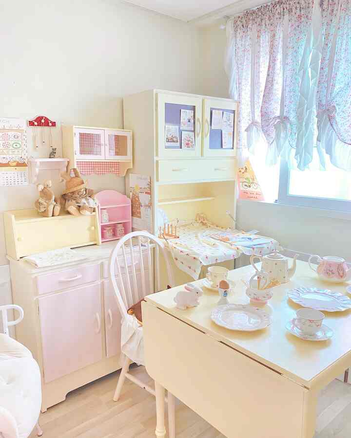 Pastel-toned vintage dining table and chair with floral curtains in a cozy home cafe kitchen space