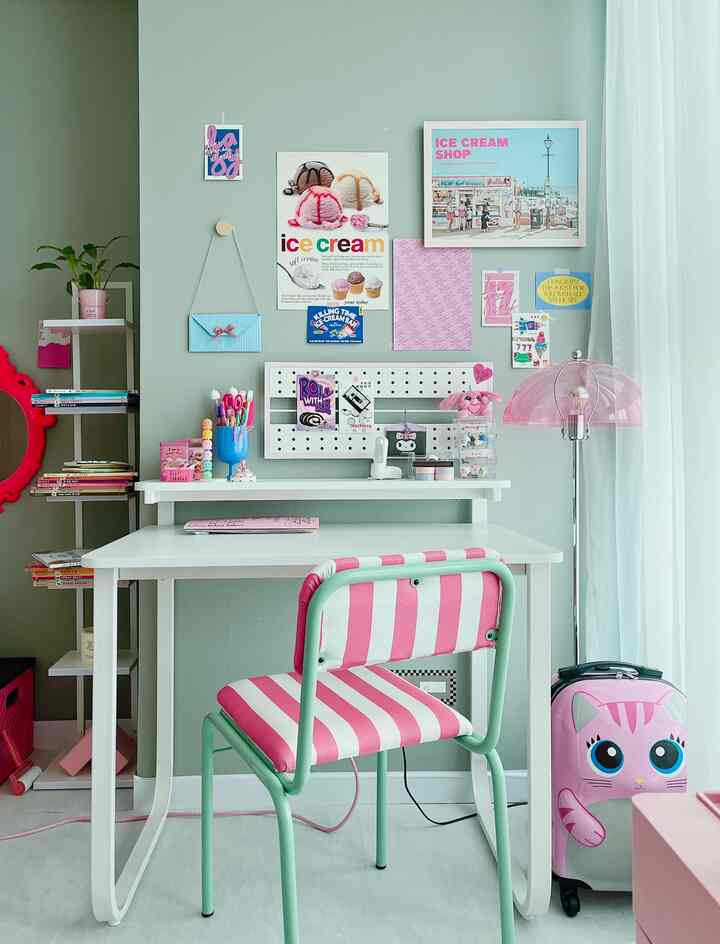 Sky blue walled kids' room with pink striped chair and clean white desk setup