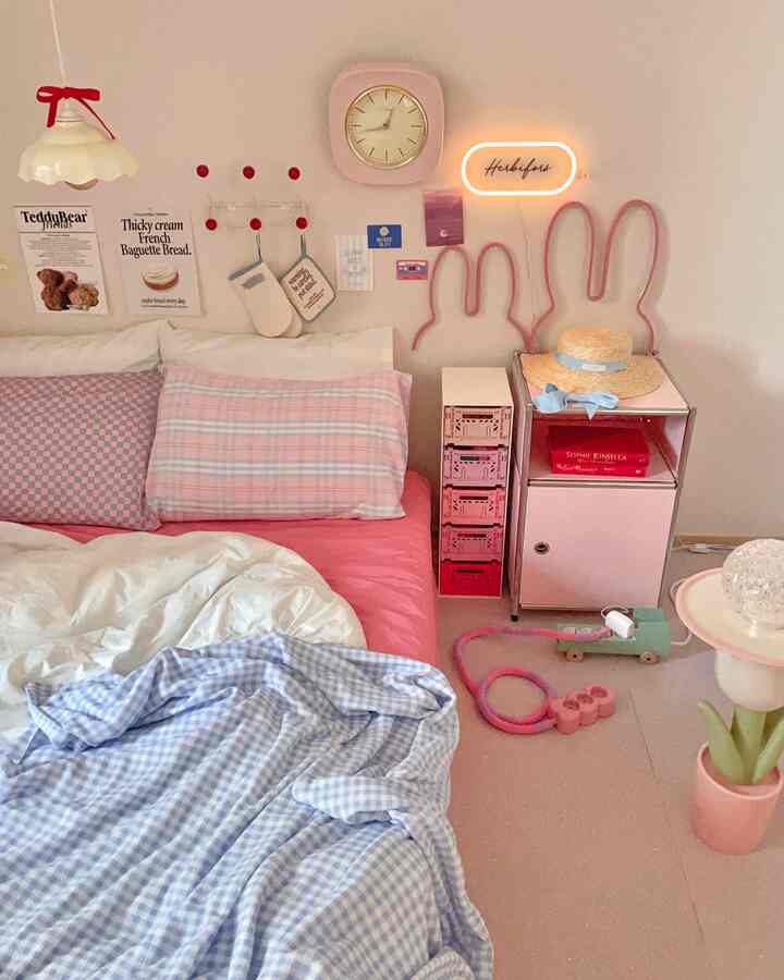 Pink and white toned bedroom featuring cute decorative accents and storage cabinet creating a cozy atmosphere
