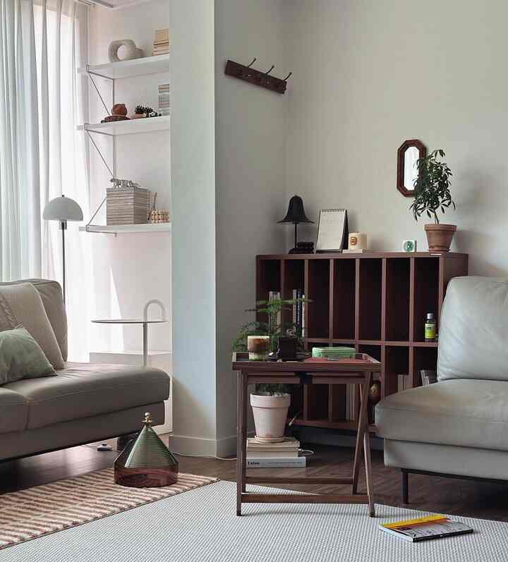 A soft ivory-toned Nordic living room with wood-tone furniture and plants arranged neatly