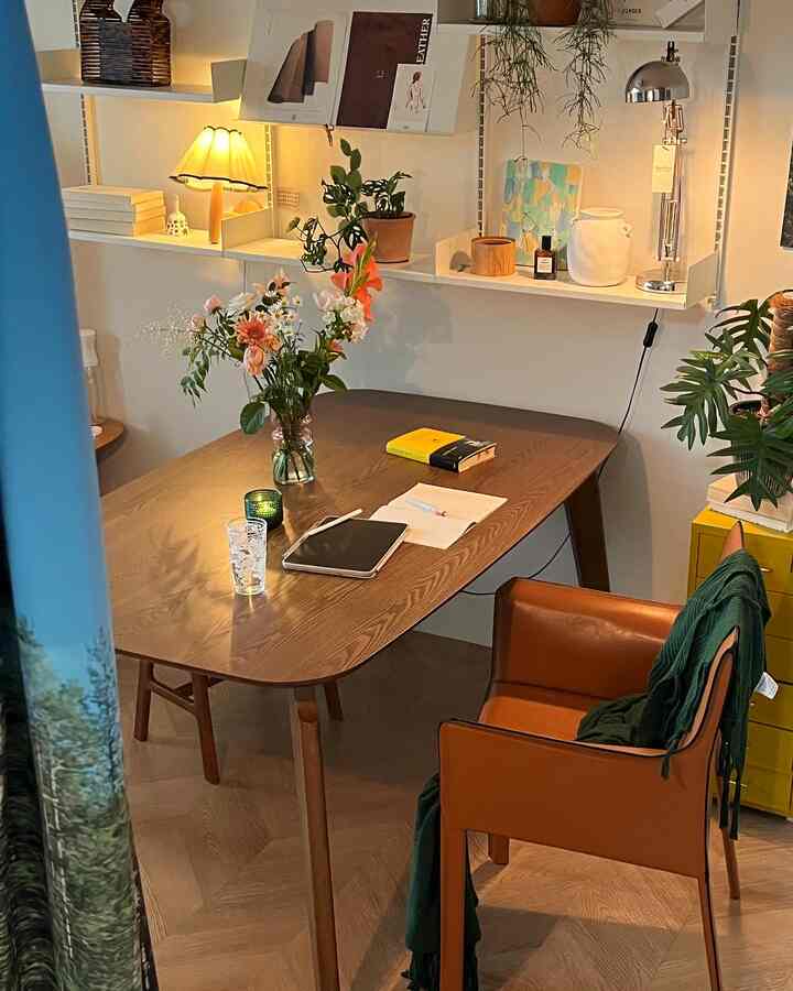 Natural wood-toned dining room featuring a wooden dining table and brown leather armchair, complemented by warm lighting and plants for a cozy ambiance