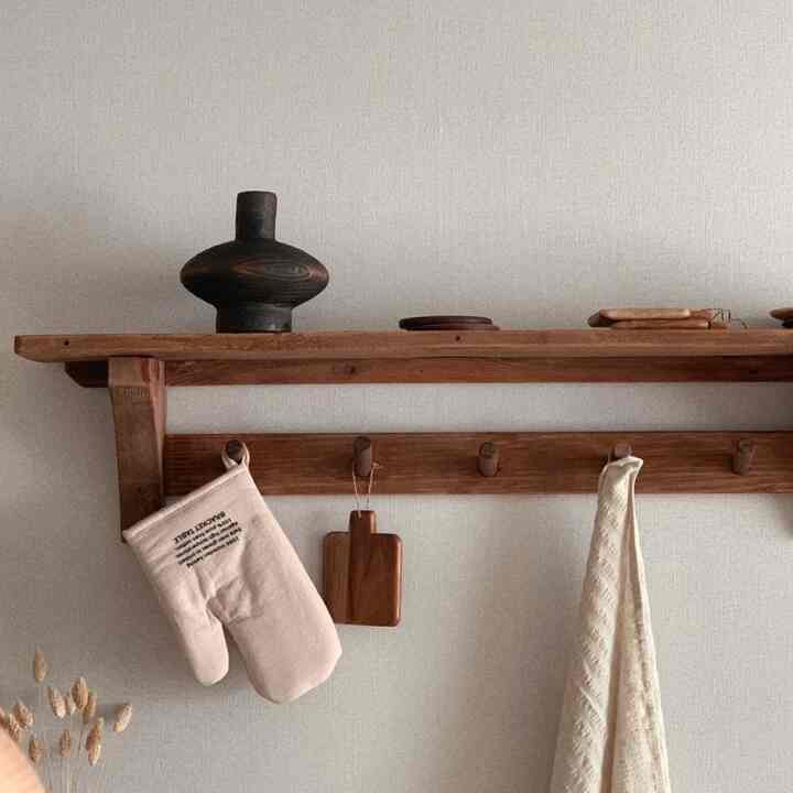 ベージュとブラウンの色調のキッチン棚、ヴィンテージの古材家具が配された温かみのあるインテリア