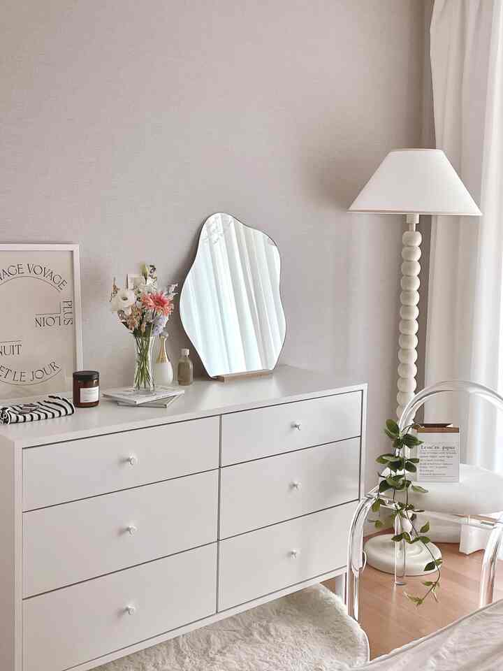 白を基調とした寝室に、化粧台とフロアランプが配置されたナチュラルモダンなインテリア