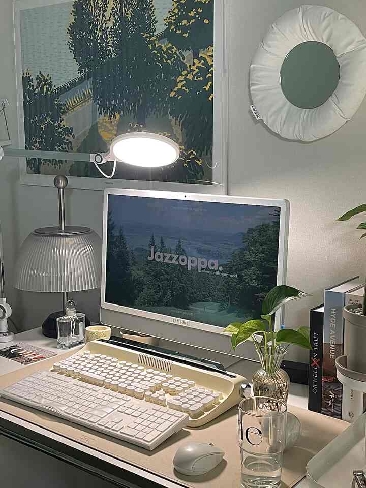 Natural tone home office desk space featuring a vintage keyboard and a plant creating a cozy atmosphere
