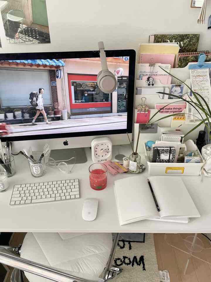 Bright white-toned home office featuring a computer and neatly organized desk with storage items in a modern workspace