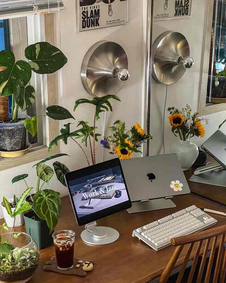 ウッドトーンとシルバーを基調にしたホームオフィス、木製デスクと植物、シルバーのiPadスタンドが配置された印象的な作業空間