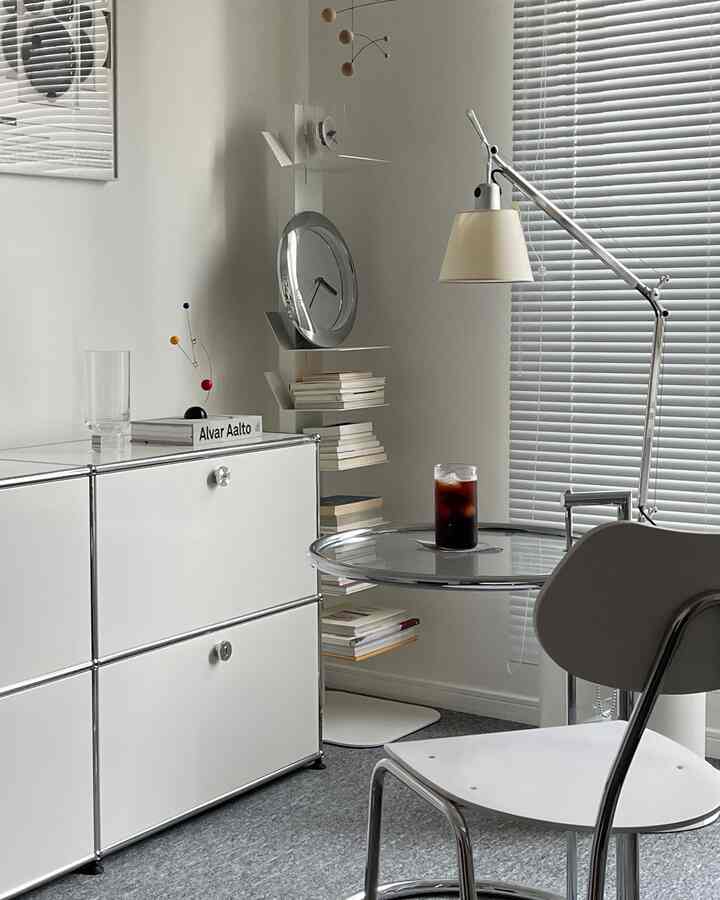 Bright white-toned compact modern space featuring sideboard, bookshelf, and coffee table with iced coffee for a home cafe vibe