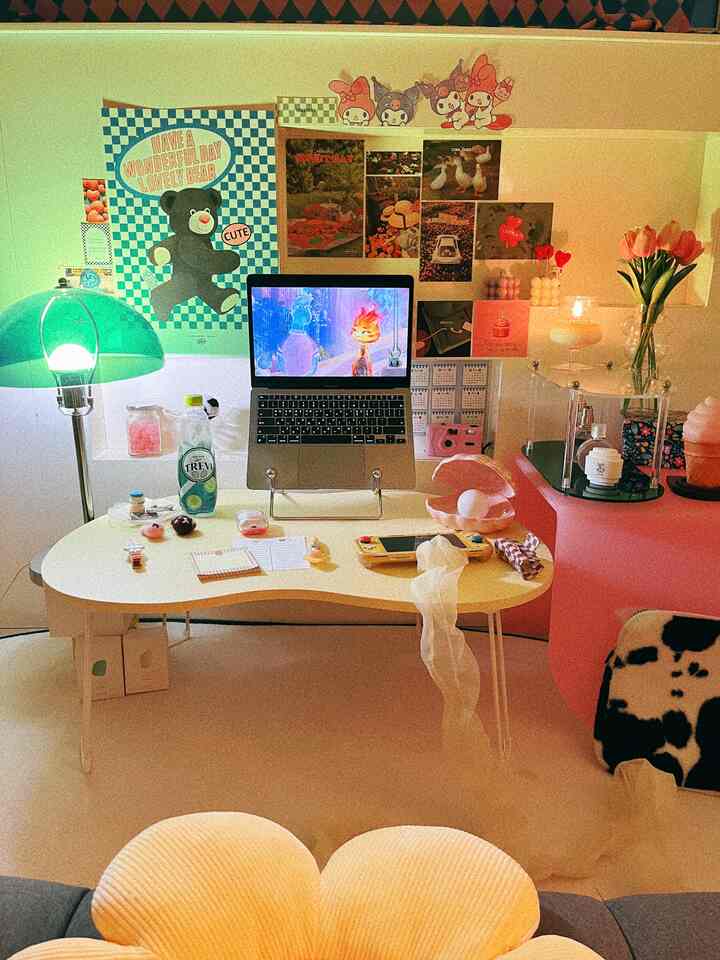 暖かいトーンのホームオフィス、ノートパソコンとテーブルランプ、ポスターが配置された雰囲気のある作業空間