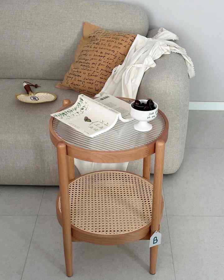 Beige and wood-toned living room featuring a rattan and wood side table with book and cherries, creating a cozy home cafe atmosphere
