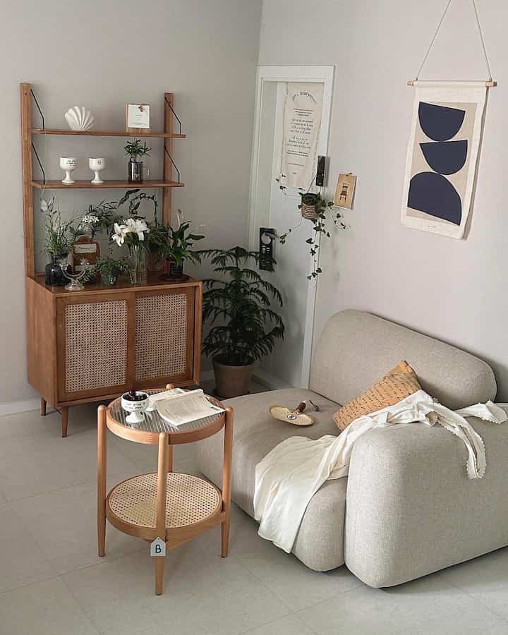 Soft beige-toned natural modern living room featuring rattan nightstand and round side table in a clean setting