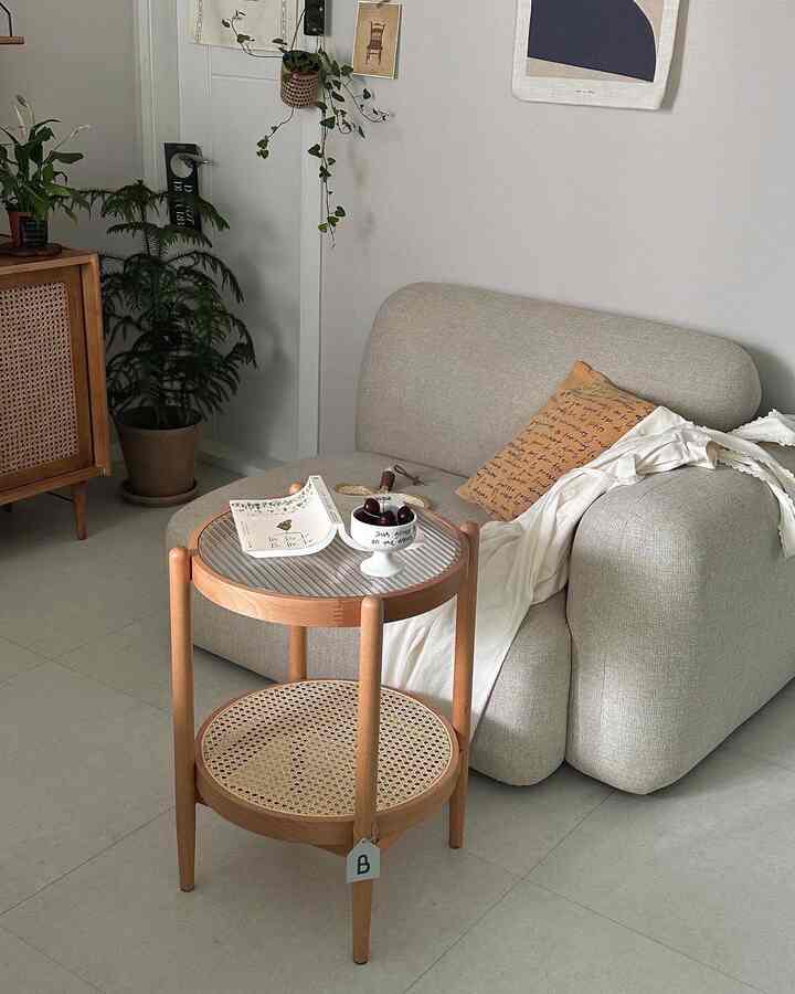 Natural color-toned living room featuring a beige sofa and rattan wood side table in a simple modern setting