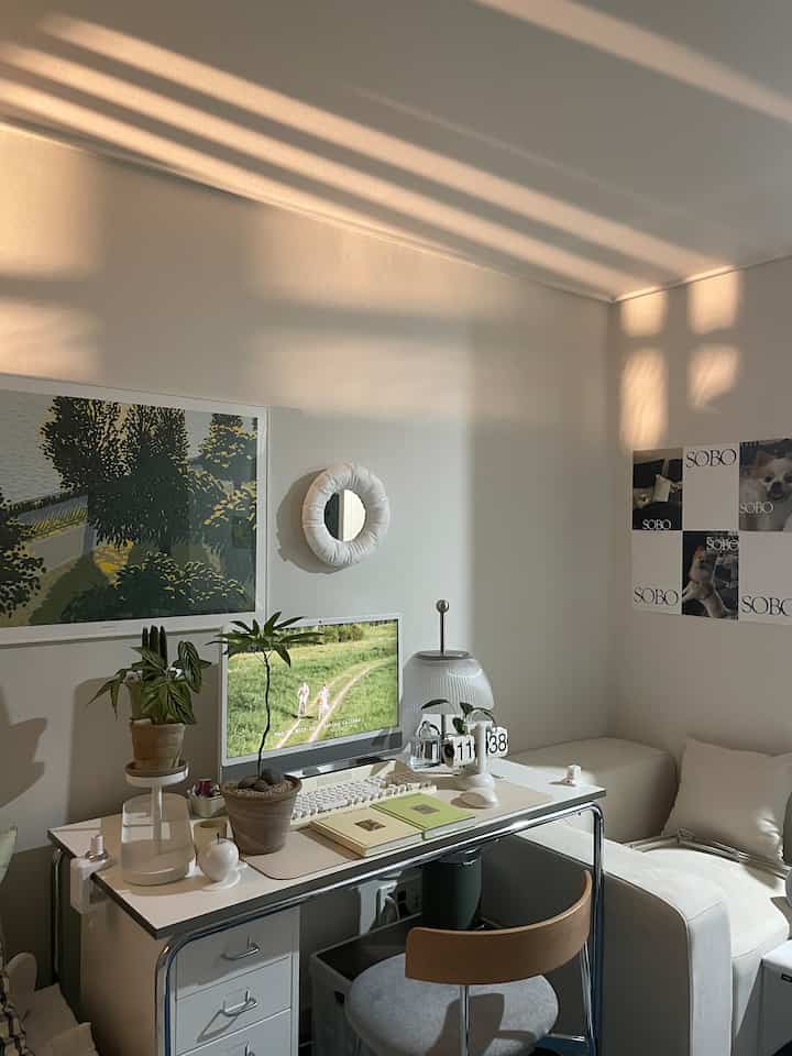 Modern home office with white walls and desk bathed in warm natural light